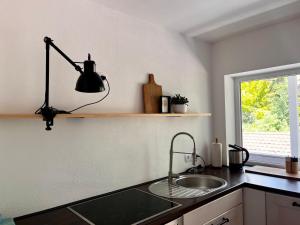 a kitchen with a sink and a lamp on the counter at Ferienwohnung IMMI in Ruhpolding +6 photos