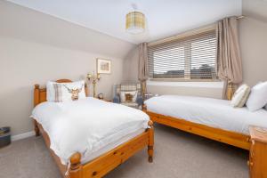 a bedroom with two beds and a window at Royal Apartment in Inverness