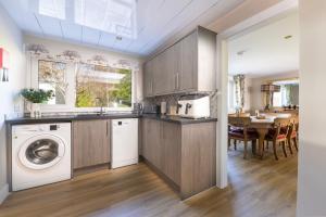 a kitchen with a washer and dryer next to a table at Royal Apartment in Inverness