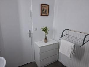 a bathroom with a toilet and a plant on a dresser at Studio moderne 33m2 Design cosy Wi Fi gratuit in Courcouronnes