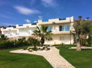 a large white building with palm trees in a yard at Villa sul Mare in Belvedere Marittimo