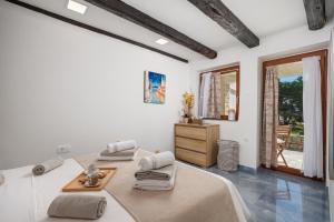 a white room with two beds and a dresser at Maestro Apartments Ičići Opatija Riviera in Ičići