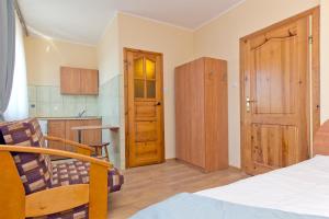 a room with a bed and a kitchen with a door at Willa Irena in Karwia