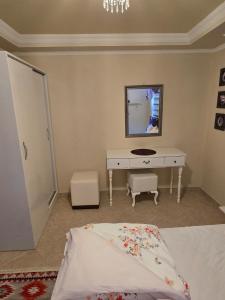 a bedroom with a bed and a dressing table and a mirror at Side Beach Villarında Dubleks Daire in Side