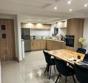 a large kitchen with a wooden table and chairs at AURA House in Krępa