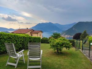 two chairs sitting on a lawn with a view of mountains at CasaDolcelago Sulzano Villa con Giardino Vista Lago Parking Free in Sulzano