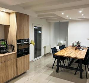 a kitchen and dining room with a wooden table and chairs at AURA House in Krępa +14 photos