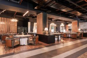 a dining room with tables and chairs and chandeliers at Swissôtel Resort Kolasin in Kolašin