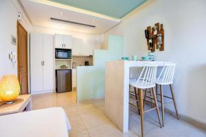 a kitchen with a counter and stools in a room at Central Thassos luxury Apartment 4u in Limenas
