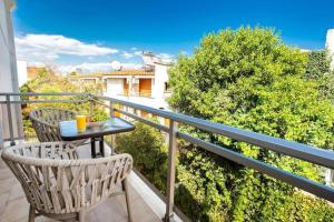 a patio with two chairs and a table on a balcony at Central Thassos luxury Apartment 4u in Limenas
