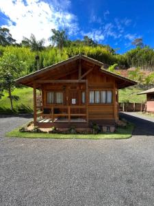 a log cabin with a gravel driveway at Pousada Casas Eleganza in Santa Teresa