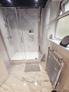 a shower with a glass door in a bathroom at Valgor -3 Bedroom House-Sleeps 5 with free parking-Ideal for contractors, families and group stays-WV6 in Tettenhall +26 photos