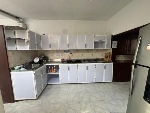 a kitchen with white cabinets and white appliances at HOTEL ASL HOME CALI NORTE - Hospedaje AV 6A NORTE in Cali