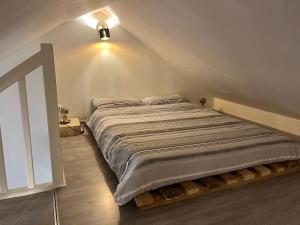 a bedroom with a large bed in a attic at La Maison d’Elise in Beine