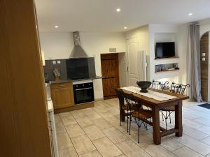 a kitchen with a wooden table and chairs and a table and a kitchen with at La Maison d’Elise in Beine