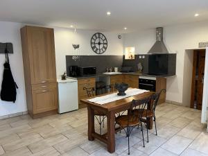 a kitchen with a wooden table and chairs in it at La Maison d’Elise in Beine