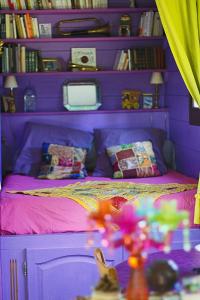 a purple bedroom with a bed with a purple wall at Roulotte de cirque à Rocamadour in Rocamadour