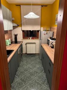 a kitchen with yellow walls and gray cabinets and a sink at Laganini Cozy Home in Velika Mlaka