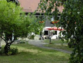 une cour avec un bâtiment, un arbre et une maison dans l'établissement Hotel Landhaus Moritzburg, à Moritzburg