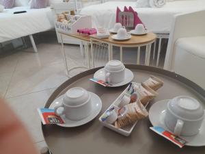 a coffee table with plates and cups on top of it at Falanga Family Guests Accommodation in Civitavecchia