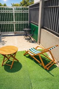 a patio with a table and a chair on the grass at Pasha House in Belgrade