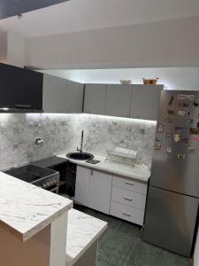 a kitchen with white cabinets and a stainless steel refrigerator at Pasha House in Belgrade