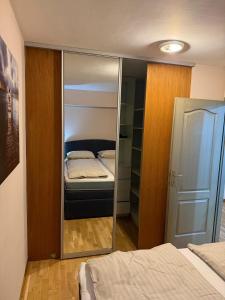 a mirror in a bedroom with a bed and a closet at Pasha House in Belgrade