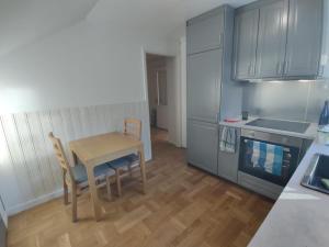 a kitchen with a table and two chairs and a table and a stove at Älgklinten with type 2 charger in Brograngen