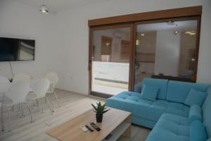 a living room with a blue couch and a table at Villa Panorama - Private heated pool and jacuzzi with ocean view in Ivanica