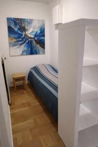 a bedroom with a bed and a painting on the wall at Älgklinten with type 2 charger in Brograngen +3 photos