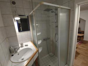 a bathroom with a shower and a sink at Älgklinten with type 2 charger in Brograngen