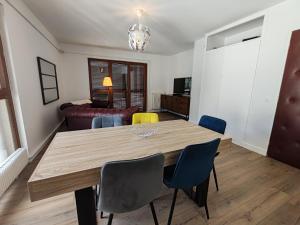 a dining room with a wooden table and chairs at Les toits du Lot in Villeneuve-sur-Lot