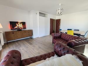 a living room with leather couches and a fireplace at Les toits du Lot in Villeneuve-sur-Lot