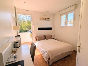 ein Schlafzimmer mit Bett, Schreibtisch und Fenster in der Unterkunft Hotel Uhainak in Hendaye