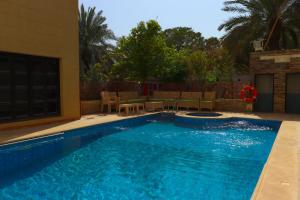 a swimming pool with blue water in a yard at Lemon Tree Guest House in Riyadh