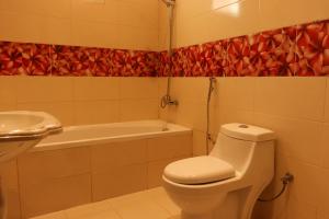 a bathroom with a toilet and a sink and a tub at Lemon Tree Guest House in Riyadh