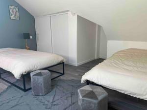 a bedroom with two beds and two stools in it at La Stracciatella Saint-Aignan in Saint-Aignan