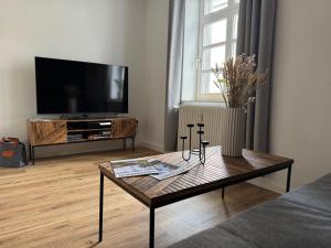 a living room with a coffee table and a flat screen tv at Altstadtnest - gemütliche Wohnung nahe der Burg in Donnerberg