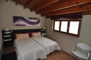 a bedroom with a bed and a chair in it at Resataurant and Rooms Cabrit in Sant Mateu