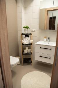 a small bathroom with a toilet and a sink at Alma Suites Győr in Győr +6 photos