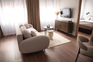 a living room with a couch and a bed at Alma Suites Győr in Győr