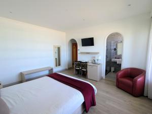 ein Hotelzimmer mit einem Bett und einem roten Stuhl in der Unterkunft Hotel Uhainak in Hendaye