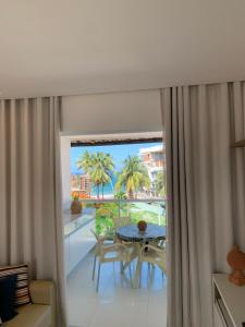a room with a balcony with a table and chairs at Solar Porto Rico in Porto De Galinhas