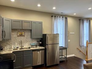 a kitchen with a stainless steel refrigerator and cabinets at Cozy Gem Mins from U of L Hospital & Downtown in Louisville