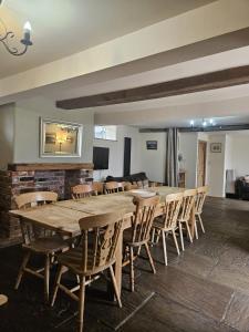 a large wooden table and chairs in a room at The Holmes Barn - Sleeps 16 - Pet friendly in Buxton