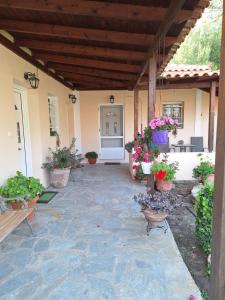 an outdoor patio with potted plants and a porch at Kerkis View House-Garden View in Karlovasi +4 photos