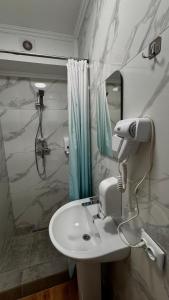 a bathroom with a white sink and a shower at Гранд Хостел in Chernivtsi +58 photos