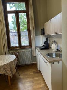a kitchen with a sink and a table and a window at La Loge Appartement 1 in Beauquesne