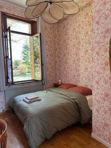 a bedroom with a bed and a window and a ceiling at La Loge Appartement 1 in Beauquesne