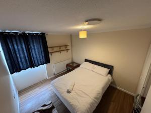 a small bedroom with a bed and a window at Amirs house in Hackington